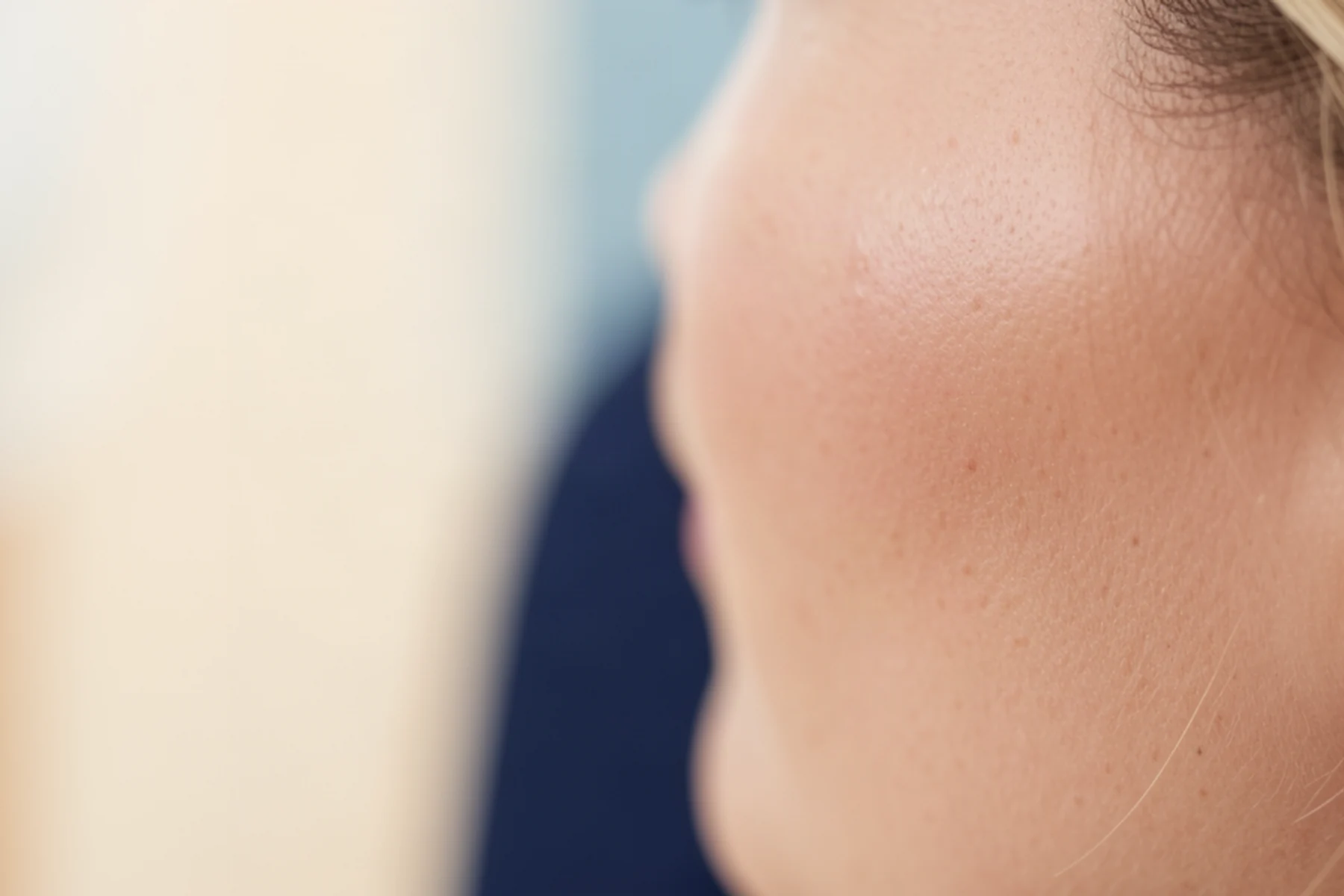 A tight cheek and temple crop shows believable smooth skin in a luxury treatment setting.